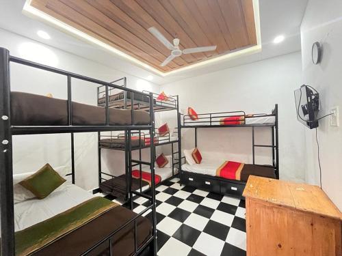 a room with two bunk beds and a checkered floor at RNB Beach Stay in Anjuna