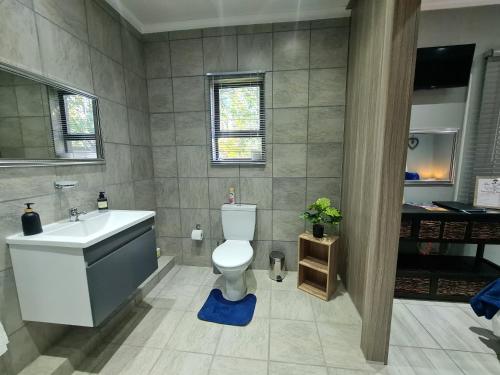 een badkamer met een wastafel, een toilet en een bad bij Rus 'n Bietjie in Bothaville