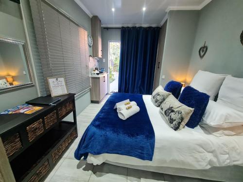 een slaapkamer met een groot bed met blauwe lakens bij Rus 'n Bietjie in Bothaville