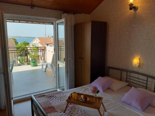a bedroom with a bed with a view of a balcony at Guesthouse Brodarica (3814) in &Scaron;ibenik