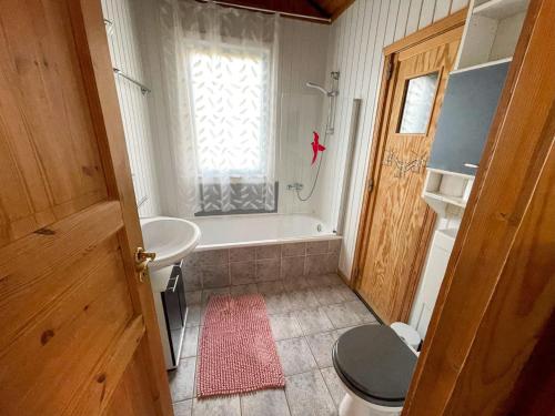 a bathroom with a tub and a toilet and a sink at Ferienhaus Sinja in Bremke