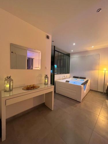 a large bathroom with a bed and a table at Appart&Spa République in Dijon