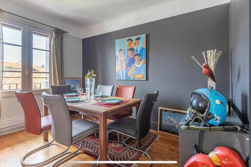 - une salle à manger avec une table et un casque dans l'établissement Exceptionnel 3 pièces art déco en dernier étage avec garage privé centre Biarritz, à Biarritz
