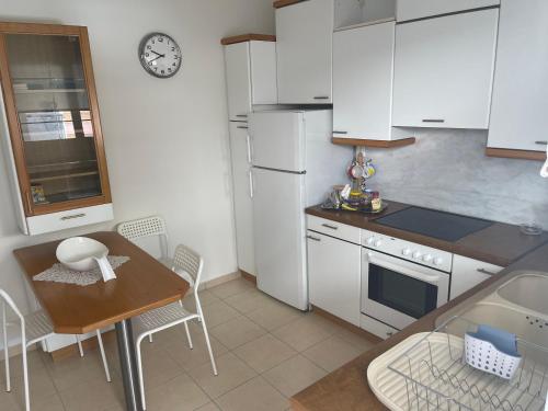 a kitchen with white appliances and a table and a table and chairs at Hotel Stella in Volos