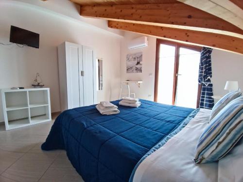 een slaapkamer met een groot bed met blauwe lakens bij Sapore di mare casa vacanze in Agropoli