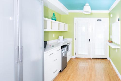 a kitchen with green walls and white cabinets at Canalside Inn in Rehoboth Beach