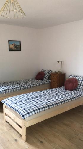 two beds sitting next to each other in a room at Siedlisko Barycz Kolonia, Dom całoroczny na wyłączność - 50 m2 6 osobowy z 2 pokojami, teren 2 hektary wśród lasów i łąk in Zwoleń