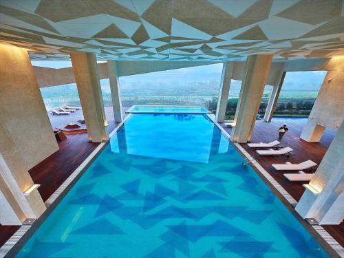 a large swimming pool in a building with windows at Vivanta New Delhi, Dwarka in New Delhi