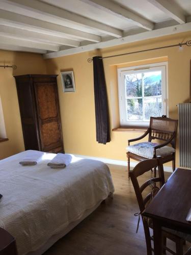 une chambre avec un lit, une fenêtre et une chaise dans l'établissement La Buissonnière, à Saint-Vincent