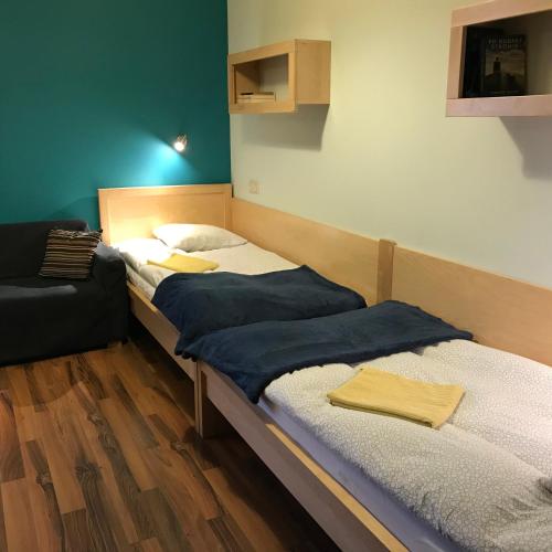 zwei Einzelbetten in einem Zimmer mit einem Stuhl in der Unterkunft Incognito in Supraśl