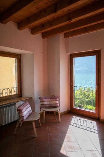 a room with two chairs and a large window at IseoLakeRental - Casa del Pescatore in Riva di Solto