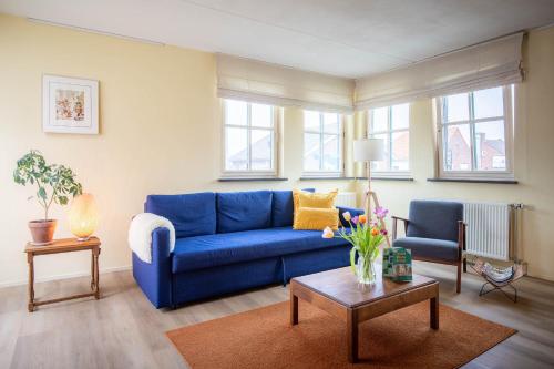 a living room with a blue couch and a table at Hotel Nieuw Antiek in Helden