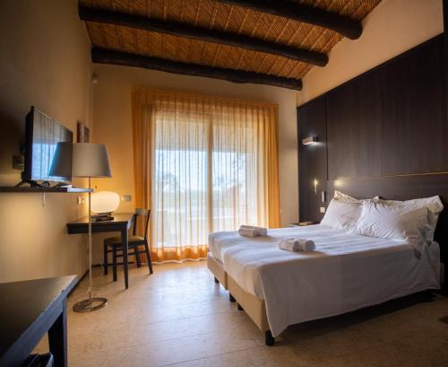 een slaapkamer met een groot wit bed en een raam bij Cambiocavallo Resort in Zimmardo