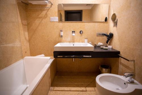 a bathroom with a sink and a tub and a toilet at Cambiocavallo Resort in Zimmardo