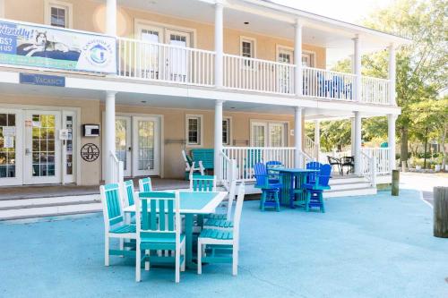 a patio with blue chairs and tables in front of a building at Canalside Inn in Rehoboth Beach
