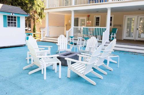 a group of white chairs and a table on a house at Canalside Inn in Rehoboth Beach