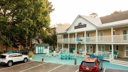 a hotel with cars parked in a parking lot at Canalside Inn in Rehoboth Beach