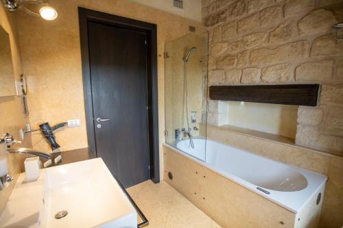a bathroom with a large tub and a sink at Cambiocavallo Resort in Zimmardo