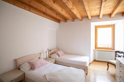 a bedroom with two beds and a window at IseoLakeRental - Casa del Pescatore in Riva di Solto