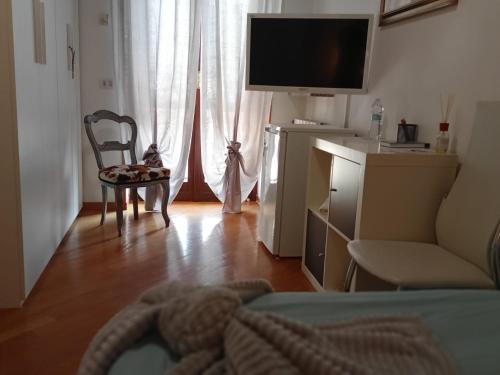 a living room with a tv and a couch and a chair at Lo sciuro in Busto Arsizio