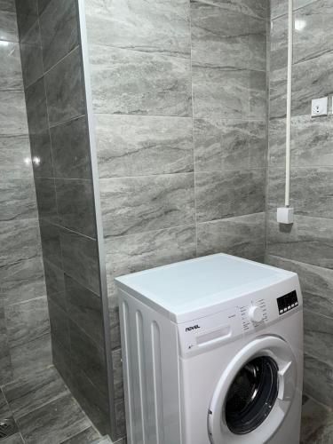 a washing machine in a bathroom with a tile wall at Old Town Bar Apartments in Stari Bar