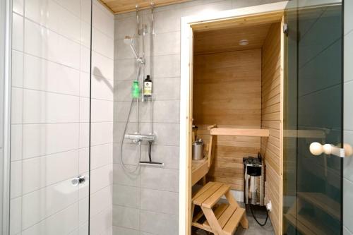 a bathroom with a shower and a bench in it at Brandnew Modern Condo with Sauna in Rovaniemi
