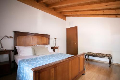 a bedroom with a large bed with a wooden headboard at IseoLakeRental - Casa del Pescatore in Riva di Solto