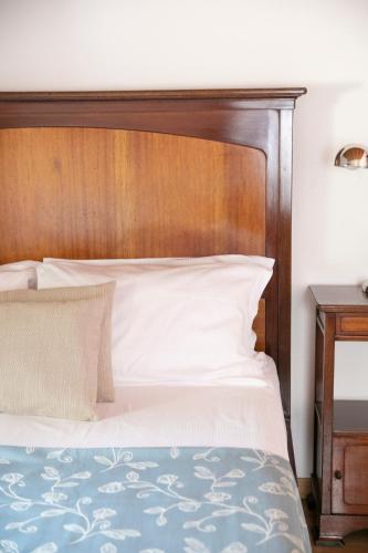 a bed with a wooden headboard in a bedroom at IseoLakeRental - Casa del Pescatore in Riva di Solto