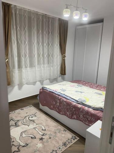 a bedroom with a bed and a rug on the floor at Lovely 1 bedroom apartment with parking in Iaşi