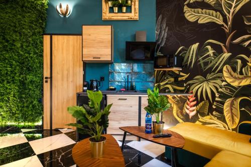 a living room with a yellow couch and plants at Jungle Apartments Podwale in Wrocław