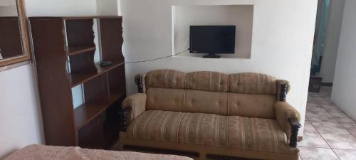 a living room with a couch and a tv at DEPARTAMENTOS AMUEBLADOS CELIA in Morelia