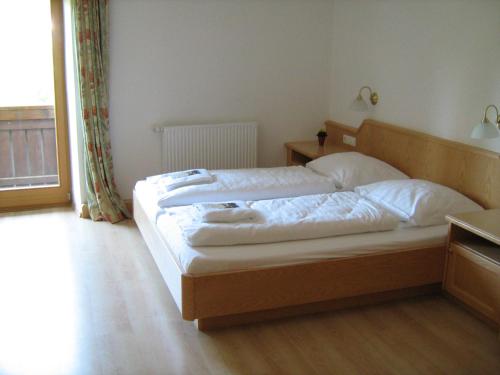 a bedroom with a large bed with white sheets at Hotel Kammerhof in Mariastein