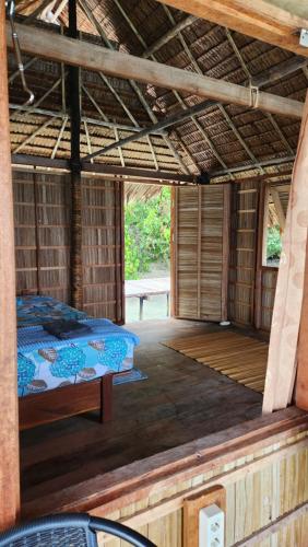 duży pokój z łóżkiem w chacie w obiekcie Terimakasih homestay w mieście Pulau Mansuar