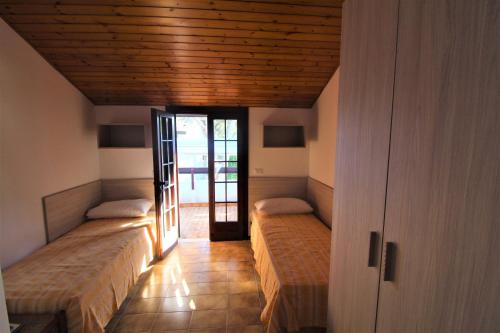 リニャーノ・サッビアドーロにあるVillaggio Burchielloの木製天井のドミトリールーム ベッド2台