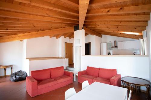 a living room with two red chairs and a table at IseoLakeRental - Casa del Pescatore in Riva di Solto