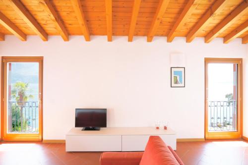 a living room with a couch and a tv at IseoLakeRental - Casa del Pescatore in Riva di Solto