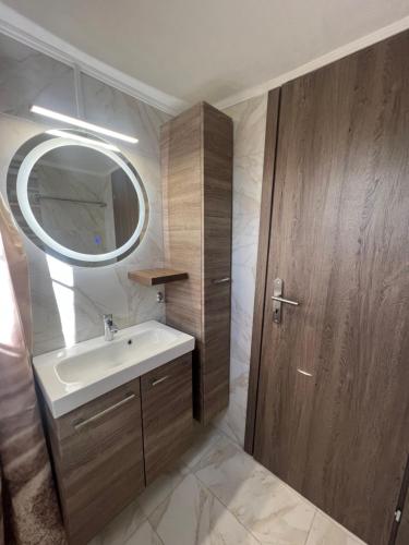 La salle de bains est pourvue d'un lavabo et d'une porte en bois. dans l'établissement Theodore resort, à Áyios Yeóryios