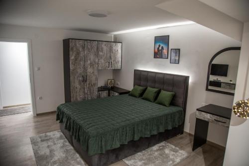 a bedroom with a bed with a green bedspread at Happy in Pirot