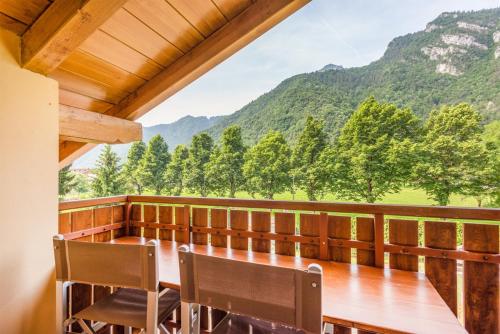 a dining room with a table and chairs and mountains at CROSINA HOLIDAY - Residence Toli in Ledro