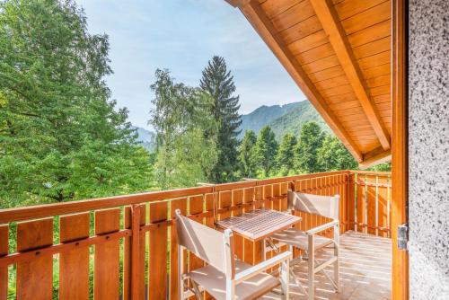 a deck with a table and chairs on it at CROSINA HOLIDAY - Residence Toli in Ledro