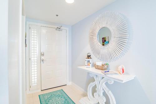 un bagno bianco con specchio e tavolo bianco di Beach Colony West Penthouse 2A By Pkrm a Pensacola