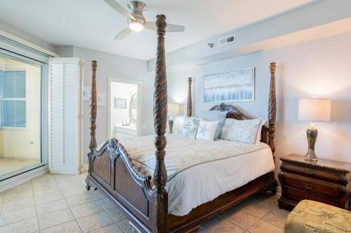 una camera con letto a baldacchino e finestra di Beach Colony West Penthouse 2A By Pkrm a Pensacola