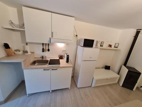 a kitchen with white cabinets and a sink and a refrigerator at Al Castello - Aeroporto delle Marche - Ancona in Falconara Marittima