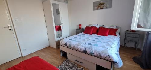 une chambre avec un lit avec des oreillers rouges dans l'établissement Belle Maison avec jardin RDC T3 de 70m2 Vacances ou cure thermale Rochefort, à Rochefort
