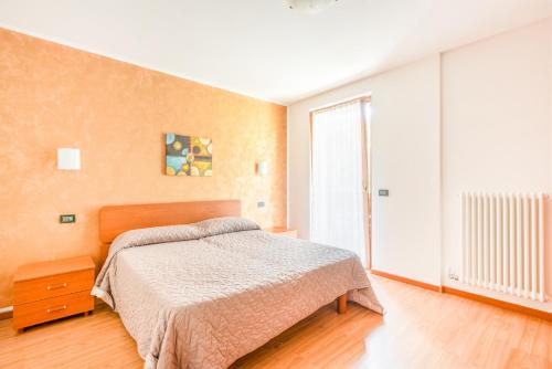 a bedroom with a bed and a large window at CROSINA HOLIDAY - Residence Toli in Ledro