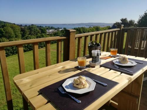 a wooden table with two plates of ice cream on it at Exe View Retreat in Dawlish Warren