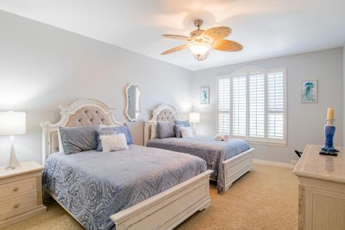a bedroom with two beds and a ceiling fan at Beach Colony West Penthouse 2A By Pkrm in Pensacola