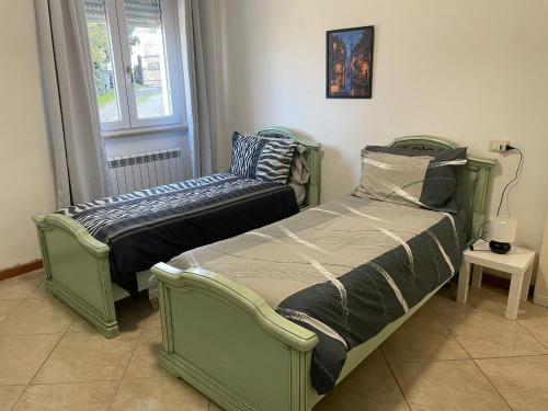 2 Einzelbetten in einem Zimmer mit Fenster in der Unterkunft Casina Gentili in Perugia
