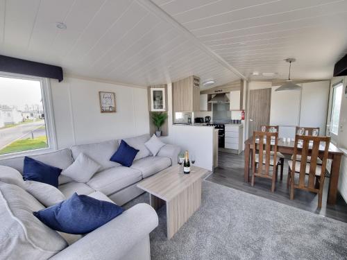 a living room and kitchen with a couch and a table at Seven Sunsets, Padstow in Padstow