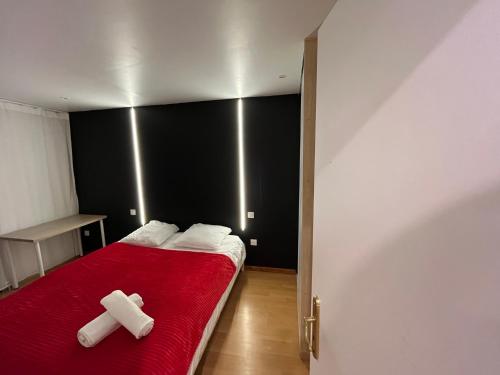 a bedroom with a red bed with two white crosses on it at PETiT MULHOUSE 201 in Mulhouse